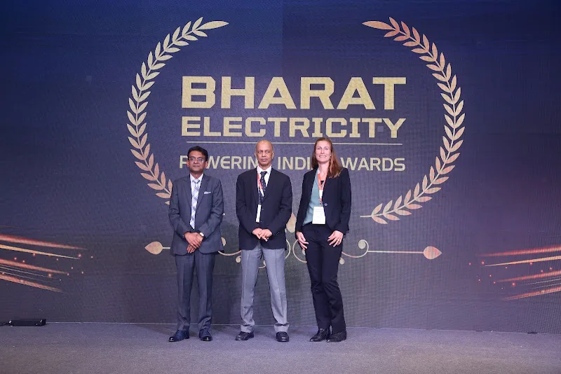 Award presenters and recipients holding a trophy on the Bharat Electricity 2024 stage