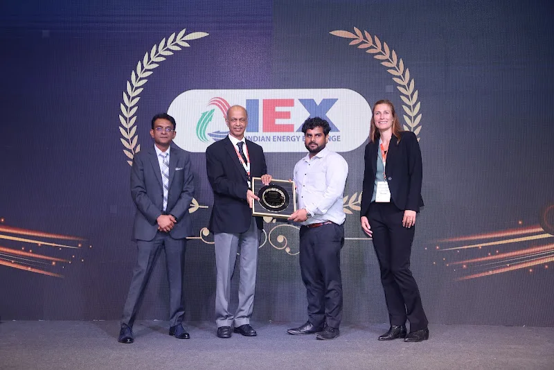 A group of award recipients displaying a trophy on stage